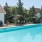 a swimming pool with chairs and umbrellas next to it