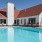 a swimming pool with chairs and a building in the background