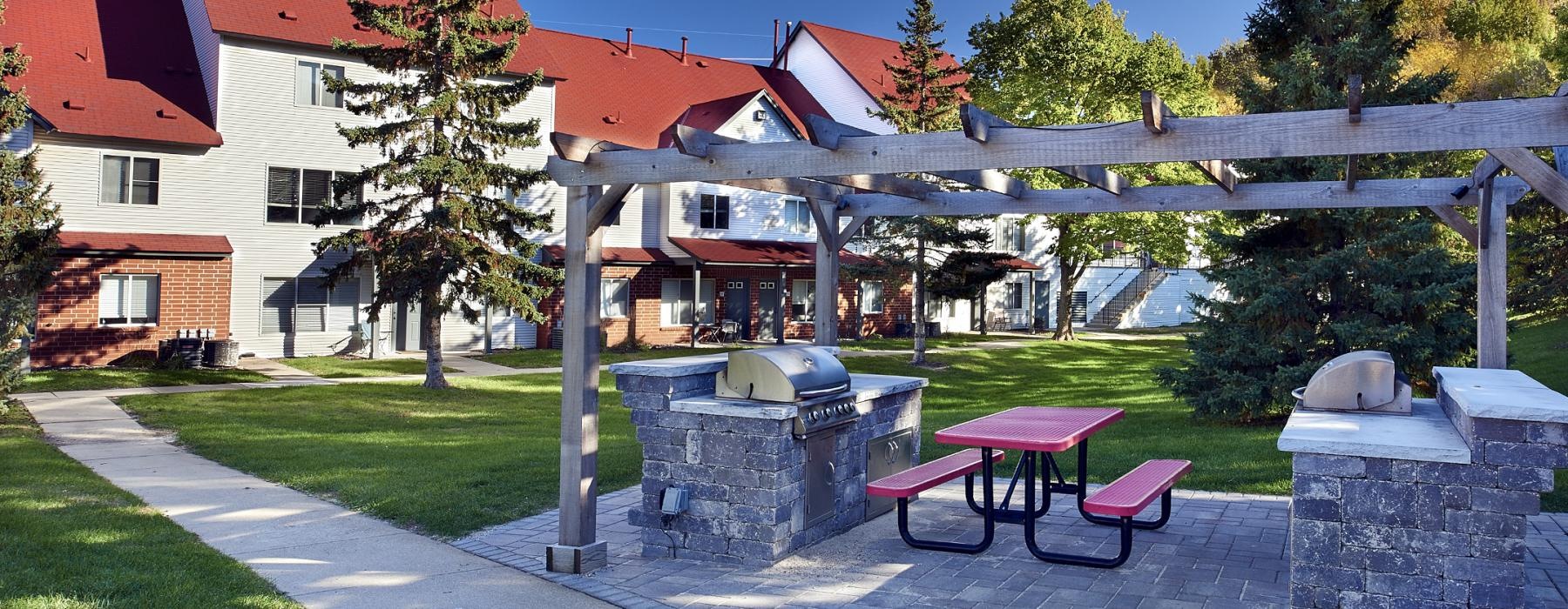 a grilling area with a picnic table